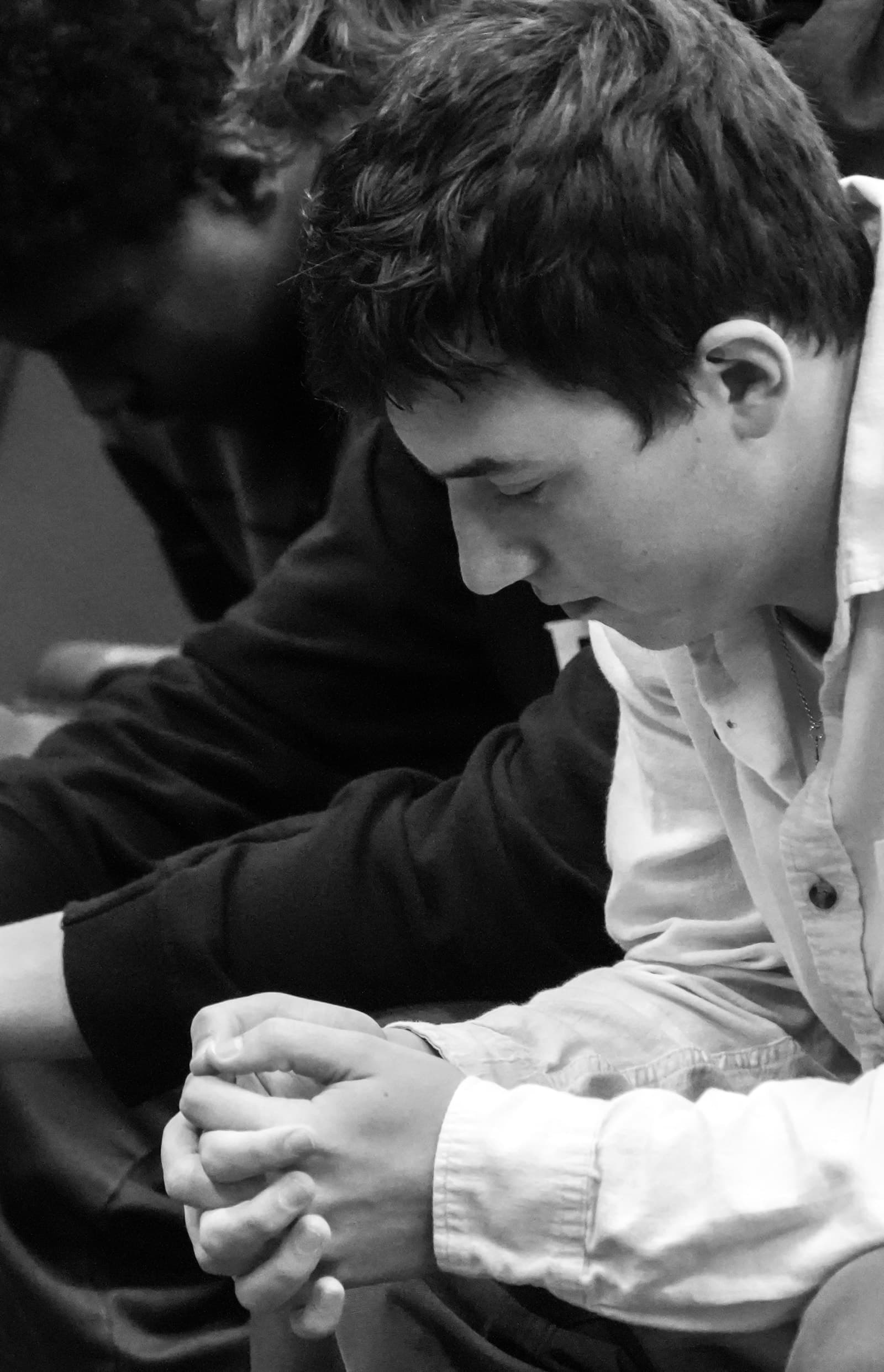 Student with hands clasped in prayer